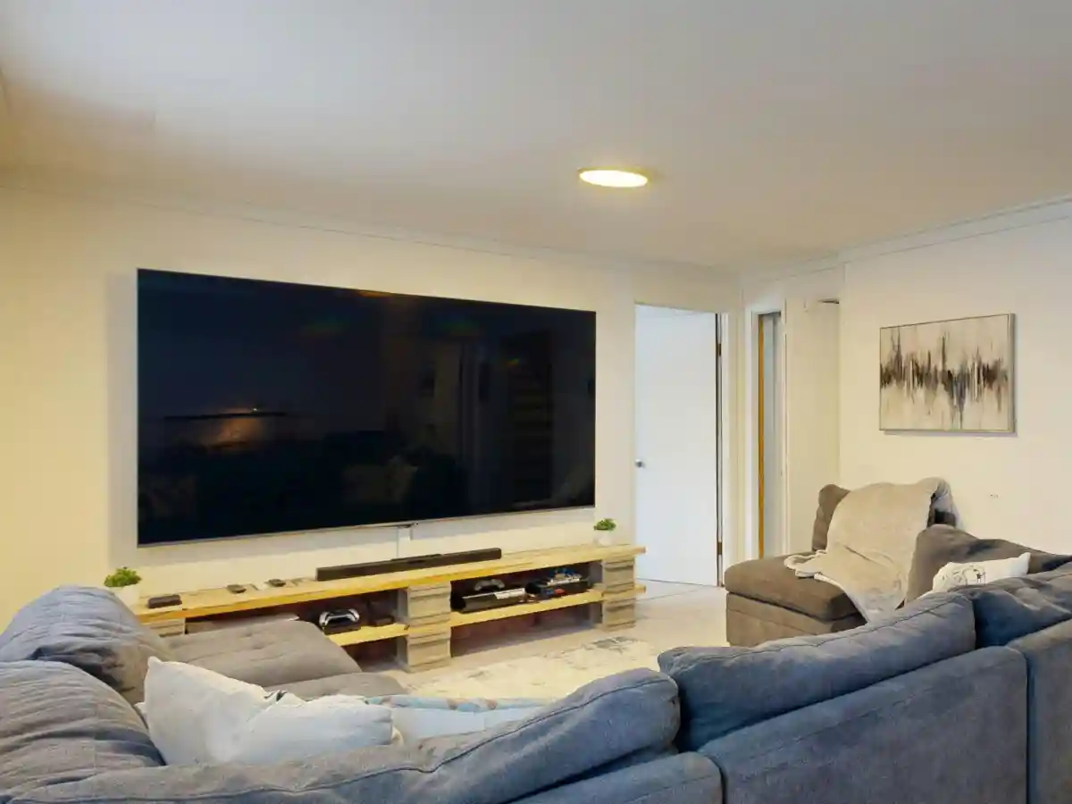 Finished basement family room with seating and lighting